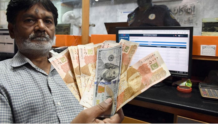 A foreign currency dealer counts US dollars at a shop in Karachi on March 2, 2023. — Online
