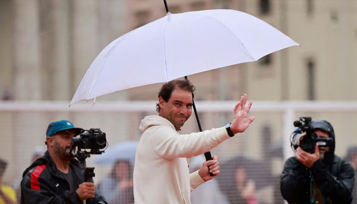 Rafael Nadal is seen with an umbrella as he meets the fans. — Reuters/File