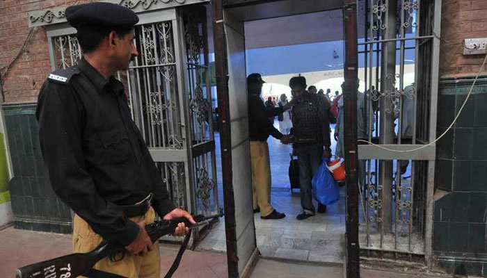 Pakistan Railway police personnel checking passengers at the railway station entrance. — AFP/File