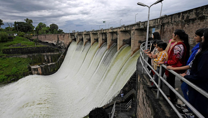 People watch the Rawal Dam after the spillway opened due to heavy monsoon rain in Pakistan. — AFP/File