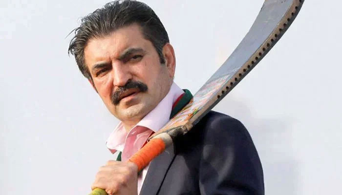 Sher Afzal Khan Marwat holds a cricket bat while speaking to supporters at a PTI rally in Karachi on January 14, 2024. — Reuters
