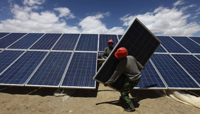This image shows workers installing a solar panel in Jiuquan, Gansu province. — Reuters/File