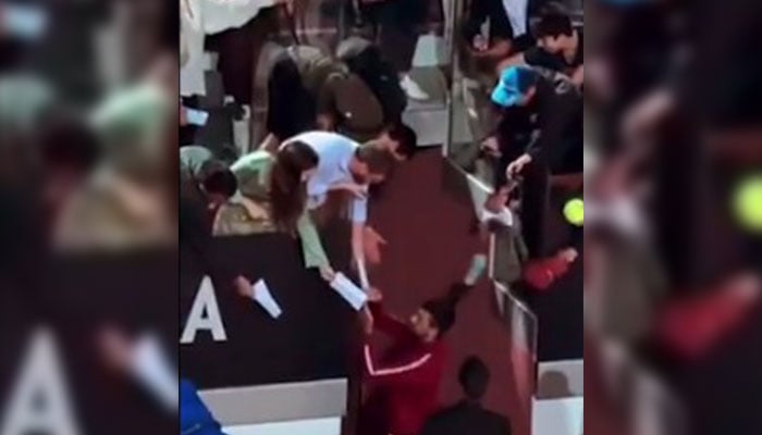 Novak Djokovic gets hit by a water bottle while signing autographs in this still taken from a video. — X/@TheTennisLetter/File
