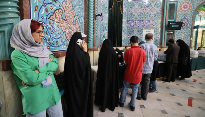Iranians queue to vote at a polling station in Tehran during the parliamentary runoff elections on May 10, 2024. — AFP