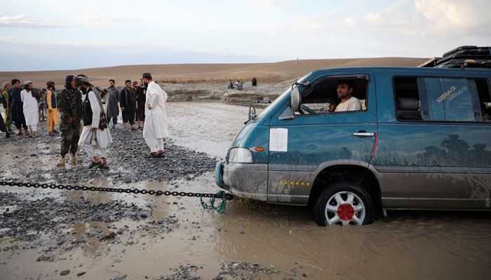 A minivan is being towed out of the flood water in the Khushi district of Logar, Afghanistan. — Reuters/File