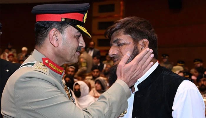 COAS General Asim Munir interacts with an attendee of the Investiture ceremony held at the GHQ on May 13, 2024. — X/@PakistanFauj