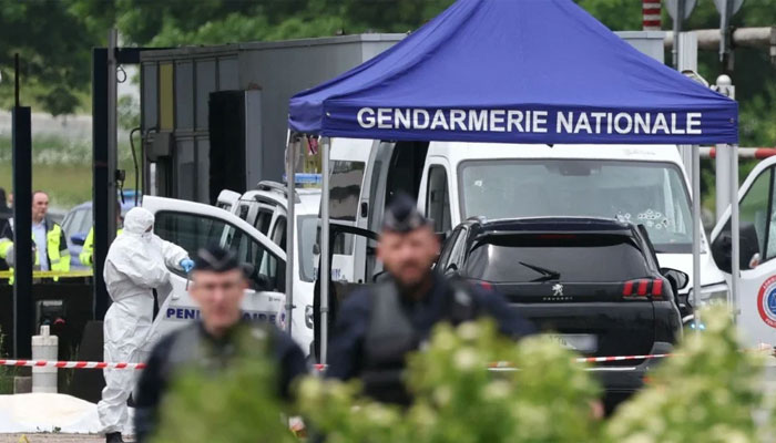 Forensic team attend an incident site as police officers patrol at the site of a ramming attack which took place late morning at a road toll in Incarville in the Eure region of northern France, on May 14, 2024. — AFP