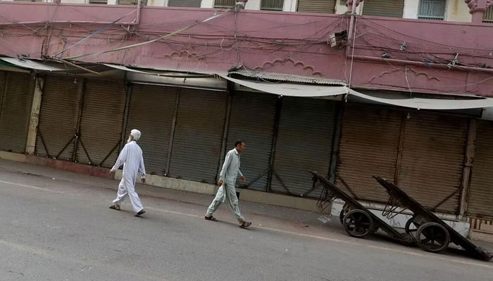 Men walk along a closed market, during a shutter down and wheel-jam strike in Pakistan. — Reuters/File