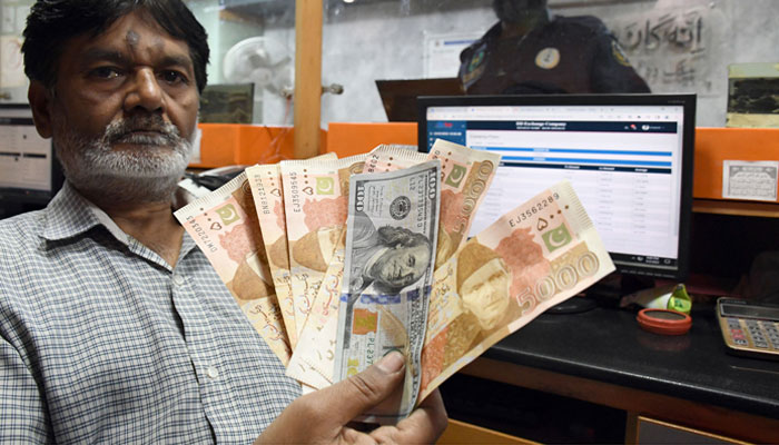 A foreign currency dealer counts US dollars at a shop in Karachi on March 2, 2023. — Online