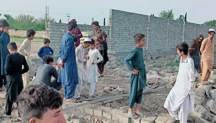 People gather outside the damaged school after militants’ set this government-run higher secondary school on fire in South Waziristan district on May 17, 2024. — District Police Wana