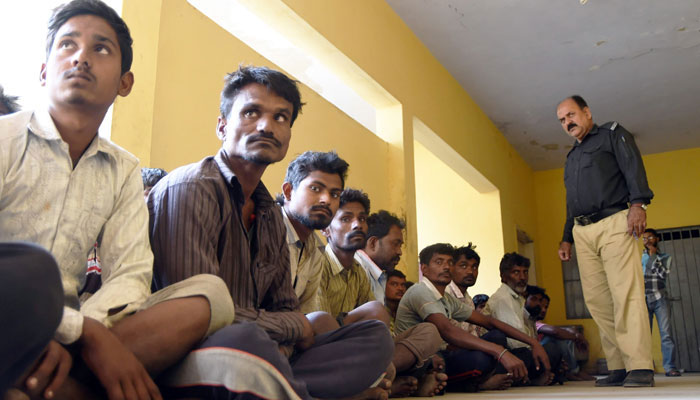 A representational image showing prisoners being guarded by a policeman. — AFP/File