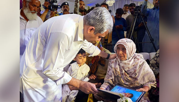 Federal Minister for Interior, Mohsin Naqvi presents allotment letter of home to the mother of a martyr in Islamabad on May 27, 2024. — PPI