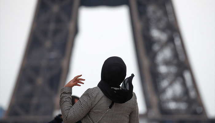 A woman wearing a hijab walks at Trocadero square near the Eiffel Tower in Paris, France on May 2, 2021. — Reuters