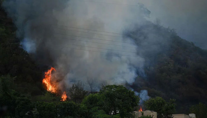 Smoke rises from a fire which erupted on Margalla Hills near Saidpur village in Islamabad on May 27, 2024. — AFP