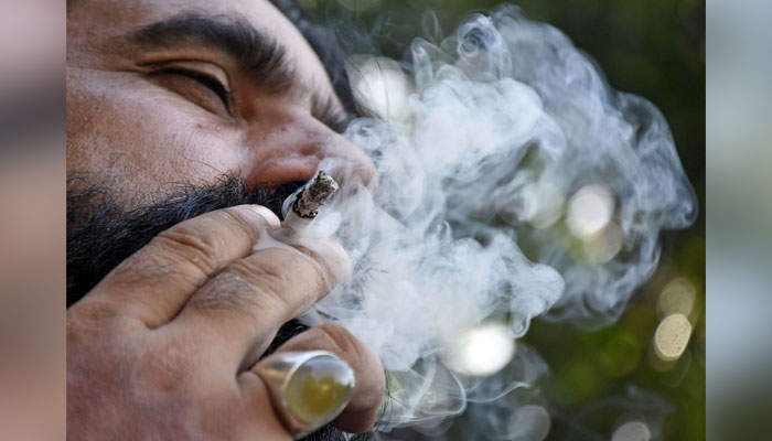 This image showing a man smoking a cigarette in Islamabad on May 30, 2024. — Online