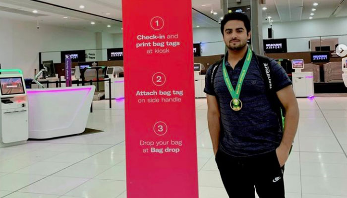 Taimoor Ayaz Khan professional squash player and World Squash Federation-recognised coach pose for a photo at Bacha Khan International Airport on April 17, 2024. — Instagram/taimoorayaz100