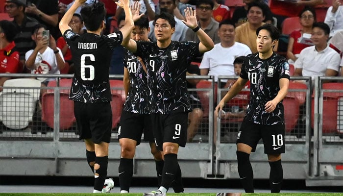 South Koreas Joo Min-kyu (centre) celebrates scoring against Singapore. — AFP/file