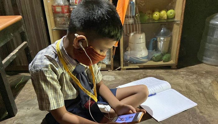 A representational image of a child using cell phone while studying. — Reuters/File