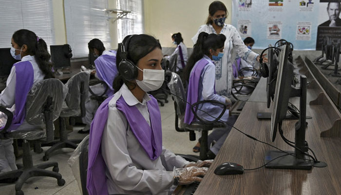 Students wearing facemasks attend a computer class at the Islamabad Model College of Commerce for Girls in Islamabad on September 15, 2020. — AFP