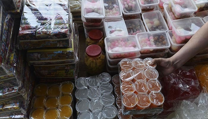 In this photograph taken on April 14, 2015, a shopkeeper arranges sweets at a wholesale market in Lahore — AFP