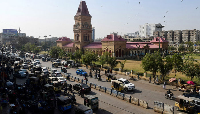 This picture taken on January 30, 2023, shows commuters passing Empress Market in Karachi. — AFP