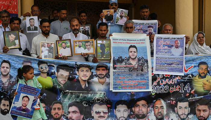 Family members hold photos of the victims of last years Greece shipwreck tragedy as they gather to mark its first anniversary, in Lalamusa a town in Punjab province on June 14, 2024. — AFP