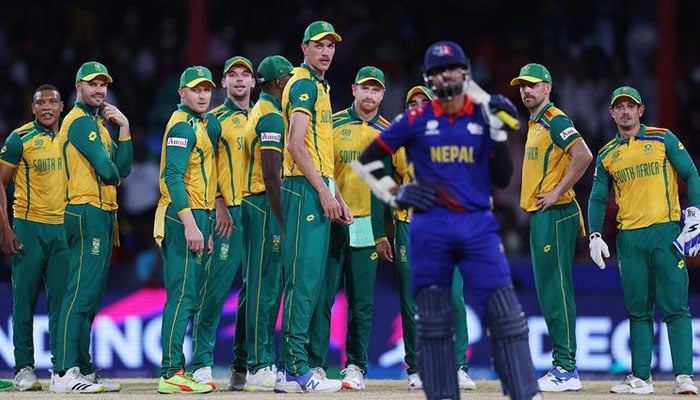 South African players standing in front of a Nepal batter.  — X@ICC