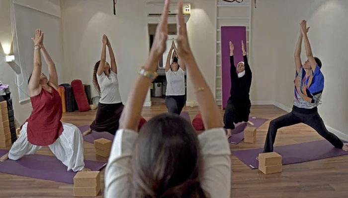 This representational image shows an instructor instructing yoga students at her studio. — AFP/File