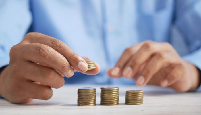 Representational image of a person stacking coins. — Unsplash/File