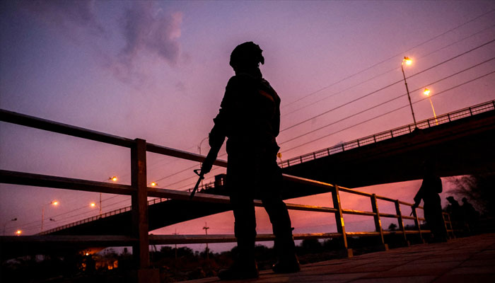 Military personnel stand guard as hundreds of refugees crossed over the river frontier between Myanmar and Thailand on Friday, following the fall of a strategic border town to rebels fighting Myanmars military junta, in Mae Sot, Tak province, Thailand, April 13, 2024. — Reuters