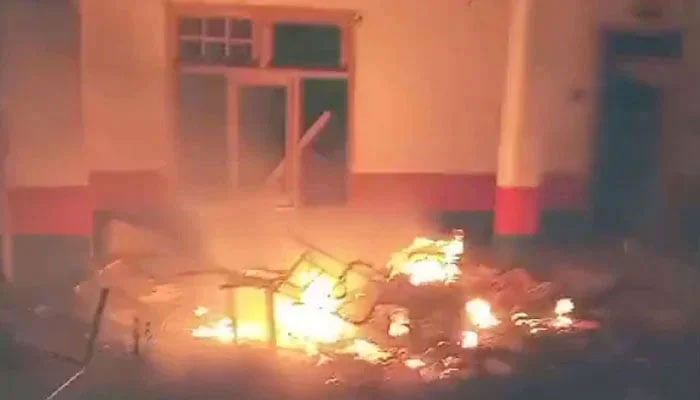 Furniture burns after being set ablaze by a mob at the Madyan Police Station on June 20, 2024. — Geo News Screengrab