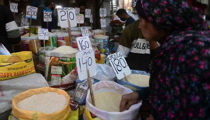 A woman checks rice prices at a main wholesale market in Karachi. — AFP/File