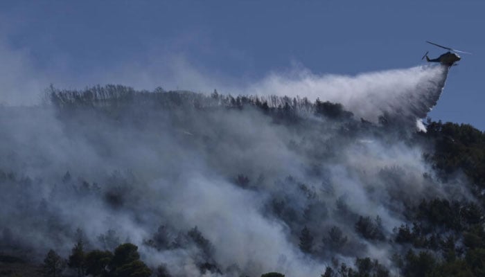 A helicopter trying to put out a wildfire in this undated image. —AFP/file