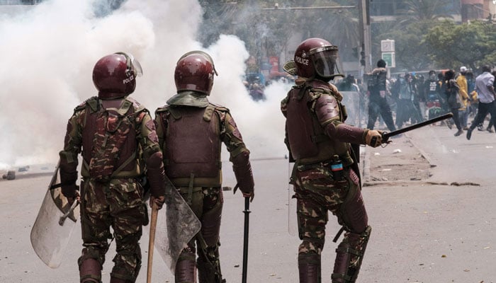 A protester gestures as a group of Kenya anti riot policemen patrol during an anti-government demonstration called following nationwide deadly protests over tax hikes and a controversial now-withdrawn tax bill in downtown Nairobi, on July 2, 2024. — AFP