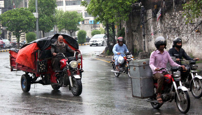 Commuters are passing through a road during downpour of monsoon season, at Shimla Hill in Lahore on  July 6, 2024. — PPI