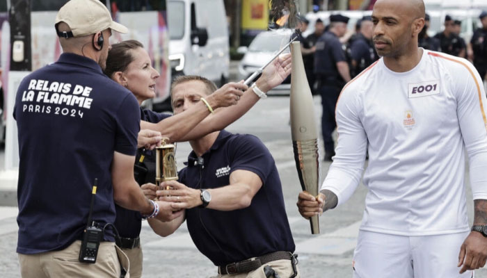 Former Arsenal and France footballer Thierry Henry, the coach of the male French Olympic team seen bearing the Olympic torch. — AFP/file