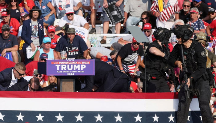 Republican Presidential candidate and former US President Donald Trump is assisted by US secret service personnel after gunfire rang out during a campaign rally at the butler farm show in butler, pennsylvania, US on July 13, 2024 — Reuters