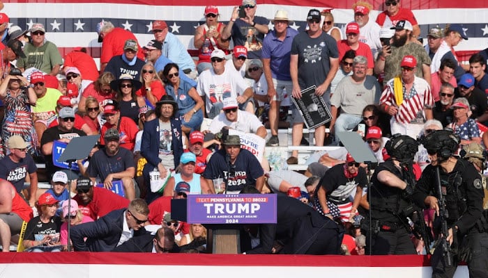 Former US President Donald Trump is assisted by US Secret Service personnel after gunfire rang out during a campaign rally at the Butler Farm Show in Butler, Pennsylvania on July 13, 2024. — Reuters