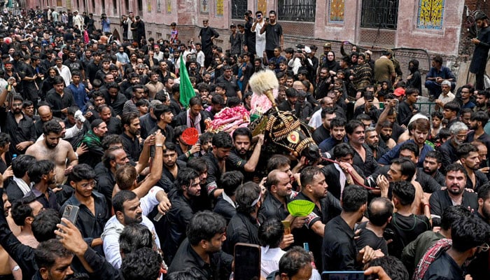 A number of people take part in a religious procession to mark Ashura on the tenth day of the Islamic month of Muharram, in Lahore on July 17, 2024. — AFP