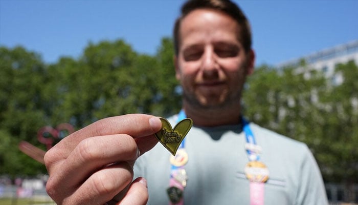 American gymnastics journalist Scott Bregman showing off his Simone Biles Paris 2024 Olympics pin he traded with her outside Bercy Arena. — Reuters