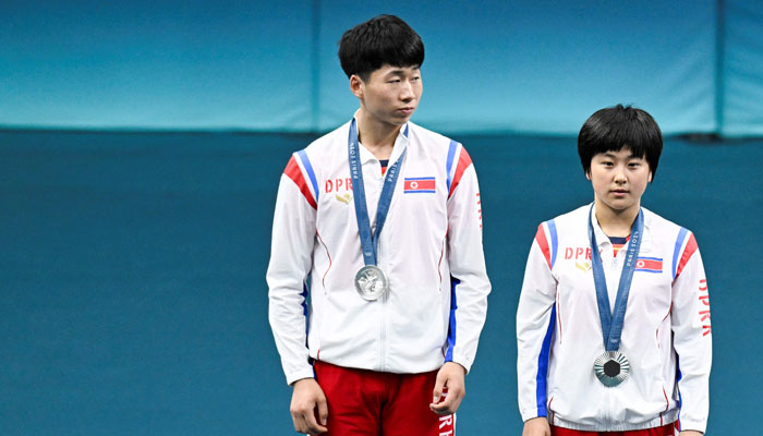 North Korean silver medalists Ri Jong Sik (L)and Kim Kum Yong pictured on the podium at the end of their mixed table tennis doubles competition at the Paris 2024 Olympic Games at the South Paris Arena in Paris on July 30, 2024. — AFP