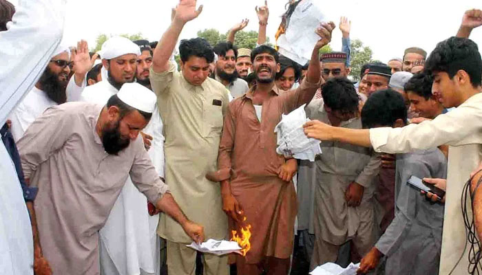Residents burn electricity bills during a protest in Peshawars Sethi Town, Khyber Pakhtunkhwa. —INP/File