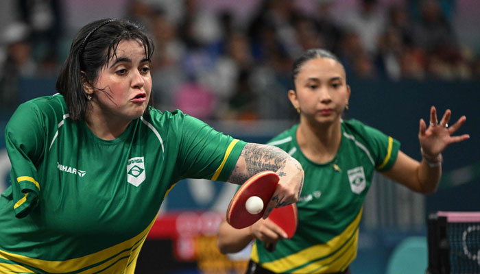 Brazils Bruna Alexandre (L) returns the ball as Brazils Giulia Takahashi (R) reacts during their womens table tennis doubles match in the team round of 16 between Brazil and South Korea at the Paris 2024 Olympic Games in Paris on August 5, 2024. — AFP
