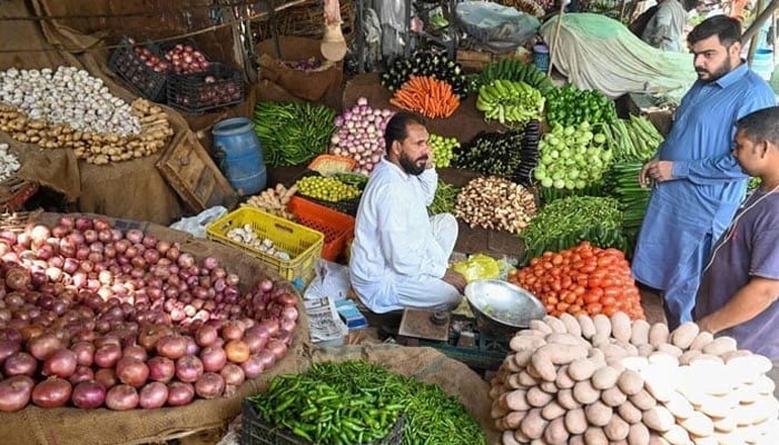This image shows the consumers buying fresh vegetables from a local market. — AFP/File