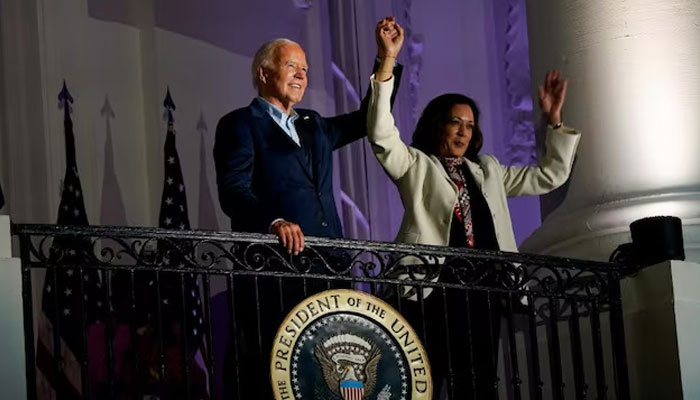 U.S. President Joe Biden (left) and Vice President Kamala Harris raise their hands during an Independence Day celebration in Washington, U.S. on July 4, 2024. — Reuters
