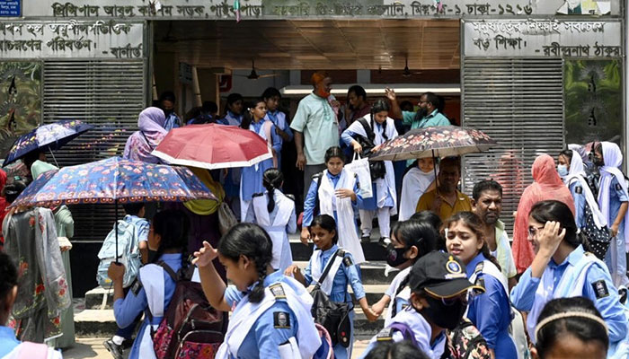 A representational students showing Bangladeshi students with umbrellas extreme heat. — AFP/File