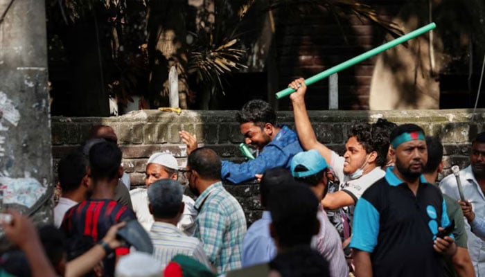 Protesters beat a suspected Awami League supporter in front of Bangabandhu Sheikh Mujibur Rahman Memorial Museum in Dhaka, Bangladesh, August 15. REUTERS