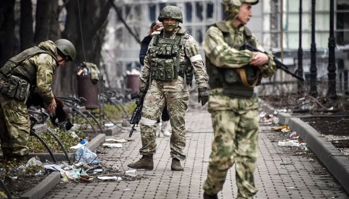 Russian soldiers walk along a street in Mariupol as troops intensify a campaign to take eastern and southern Ukraine. — AFP/File