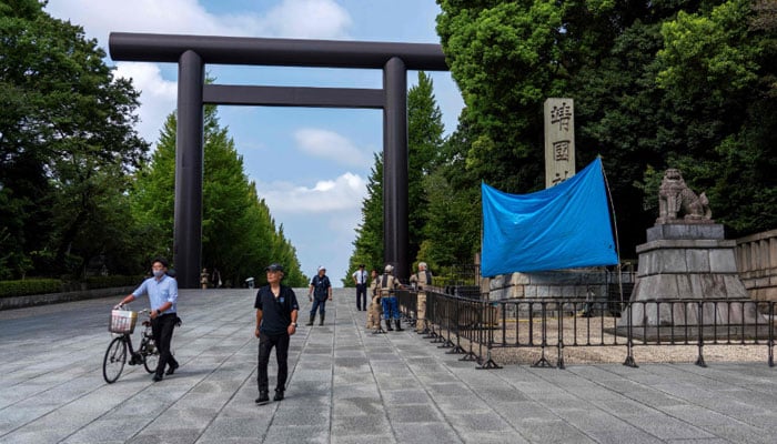 A blue sheet obscures the stone pillar which bears the name of the Yasukuni Shrine, after graffiti was found on the structure at the entrance to the shrine in Tokyo on August 19, 2024. — AFP