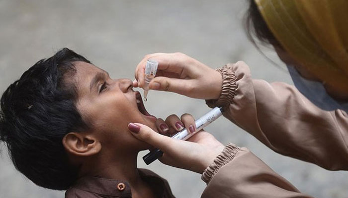 A health worker administers polio drops to a child during a door-to-door vaccination campaign in Karachi on August 7, 2023. — AFP